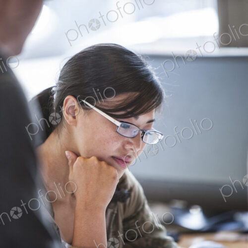 Asian woman leading an informal meeting in a creative office. Asian woman leading an informal meeting in a creative office.
