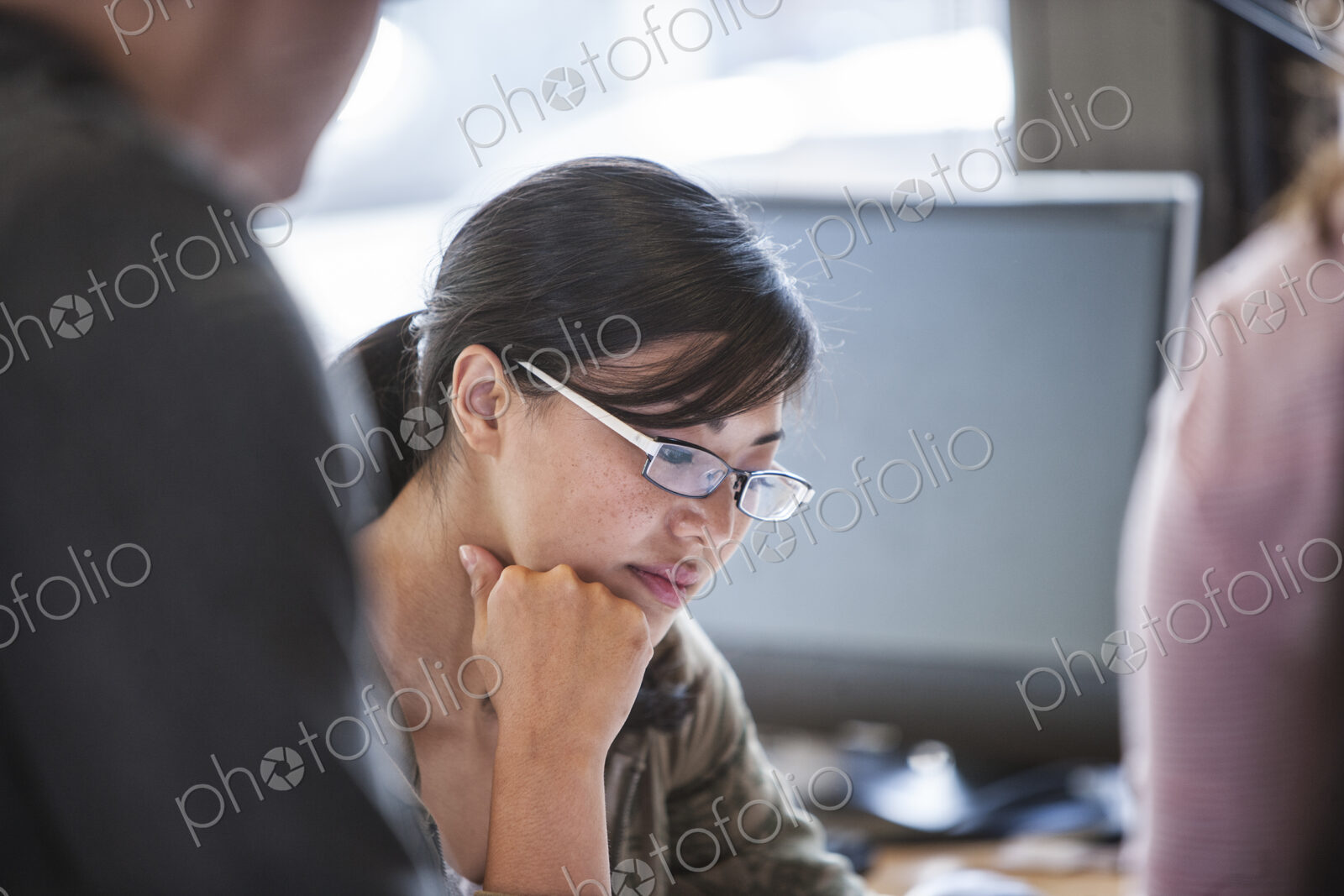 Asian woman leading an informal meeting in a creative office.