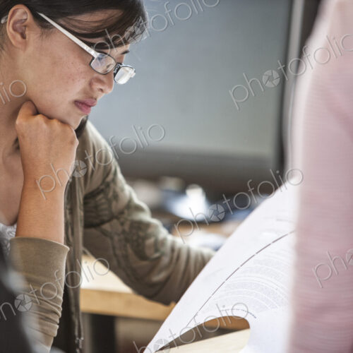Asian woman leading an informal meeting in a creative office. Asian woman leading an informal meeting in a creative office.