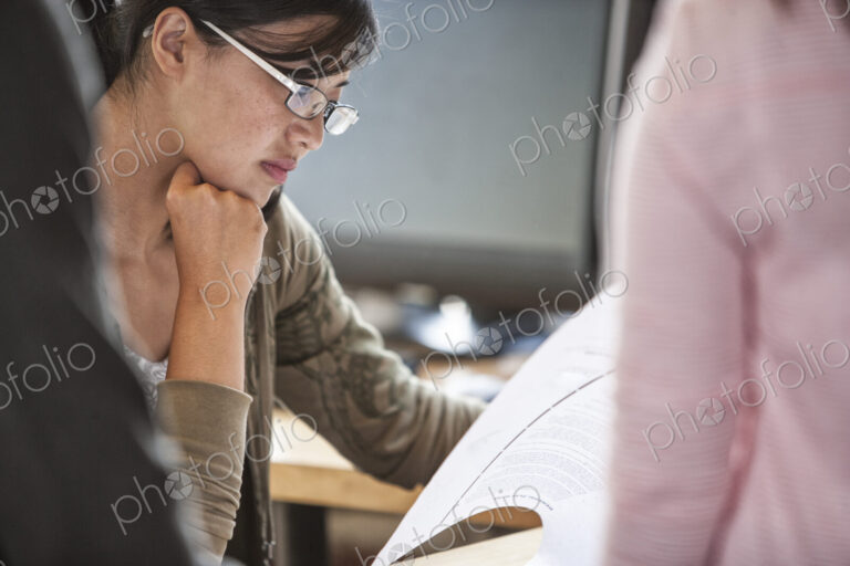 Asian woman leading an informal meeting in a creative office.