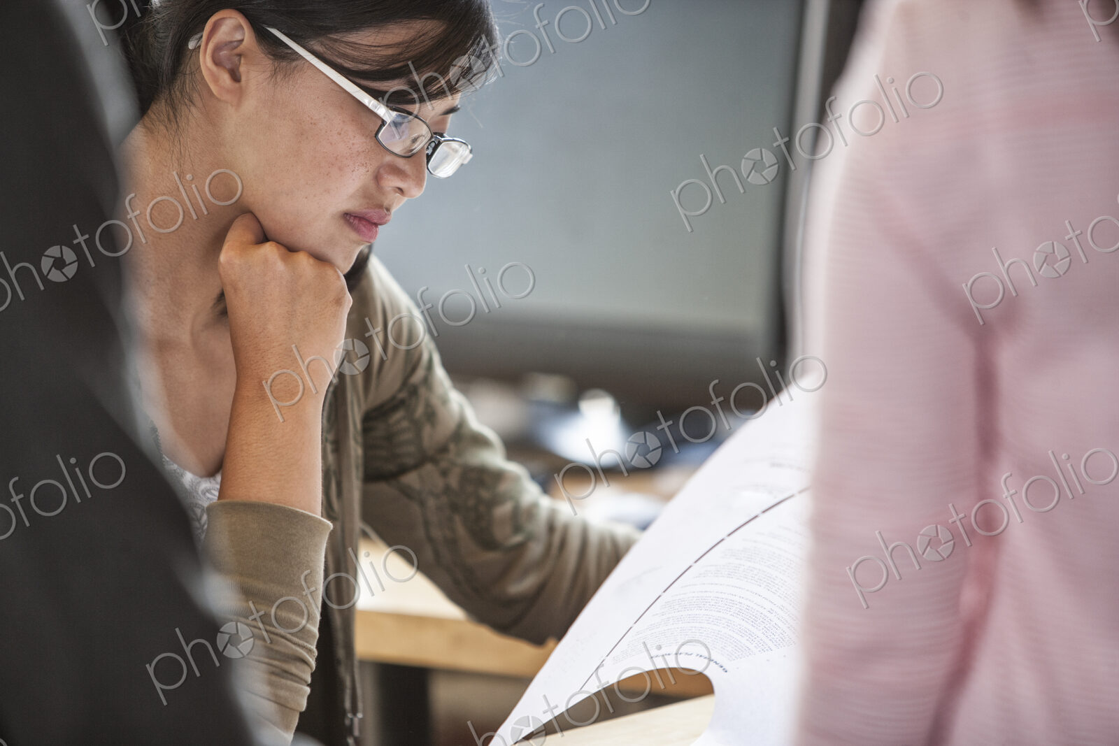 Asian woman leading an informal meeting in a creative office.