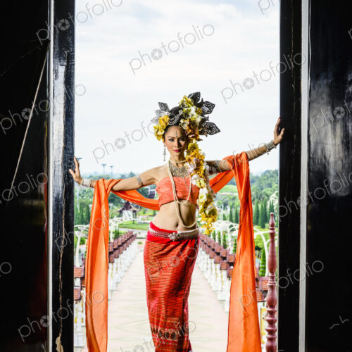 Asian woman standing in ornate temple doorway, Chiang Mai, Chiang Mai, Thailand Asian woman standing in ornate temple doorway, Chiang Mai, Chiang Mai, Thailand