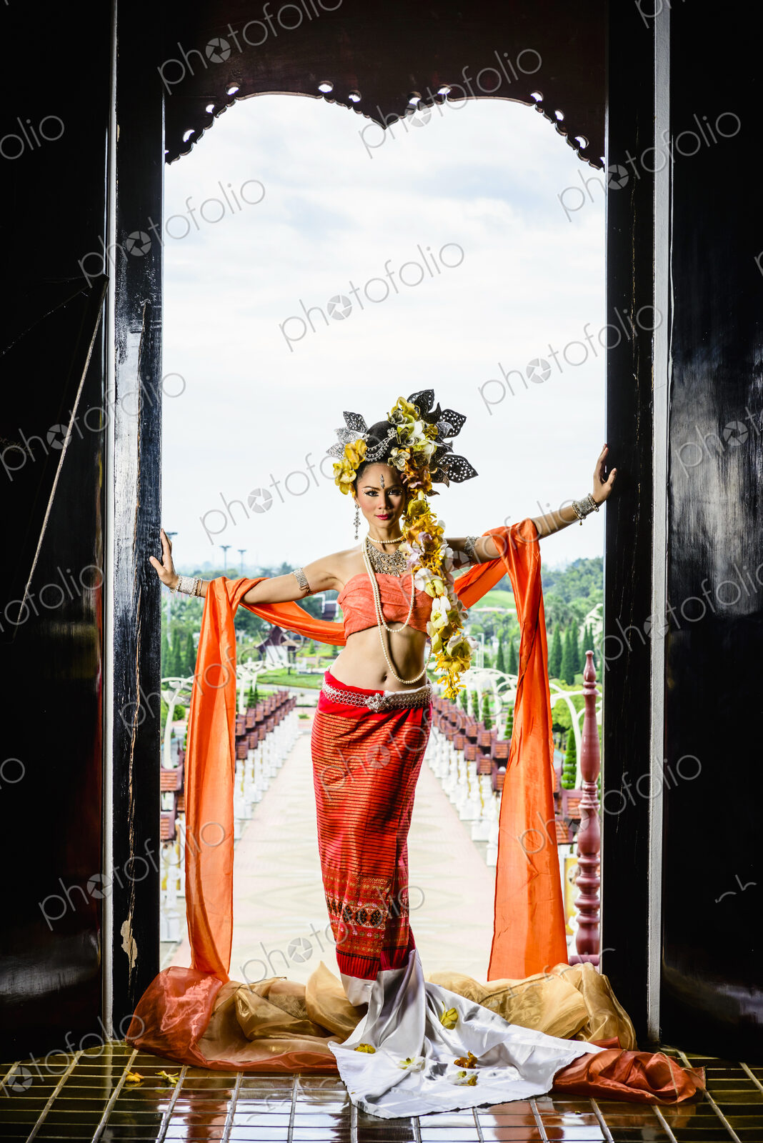 Asian woman standing in ornate temple doorway, Chiang Mai, Chiang Mai, Thailand