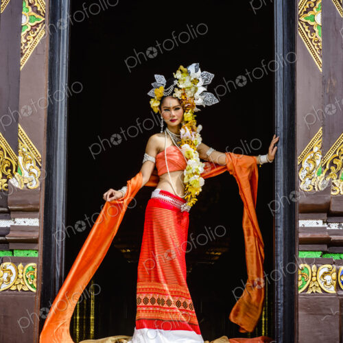 Asian woman standing in ornate temple doorway, Chiang Mai, Chiang Mai, Thailand Asian woman standing in ornate temple doorway, Chiang Mai, Chiang Mai, Thailand
