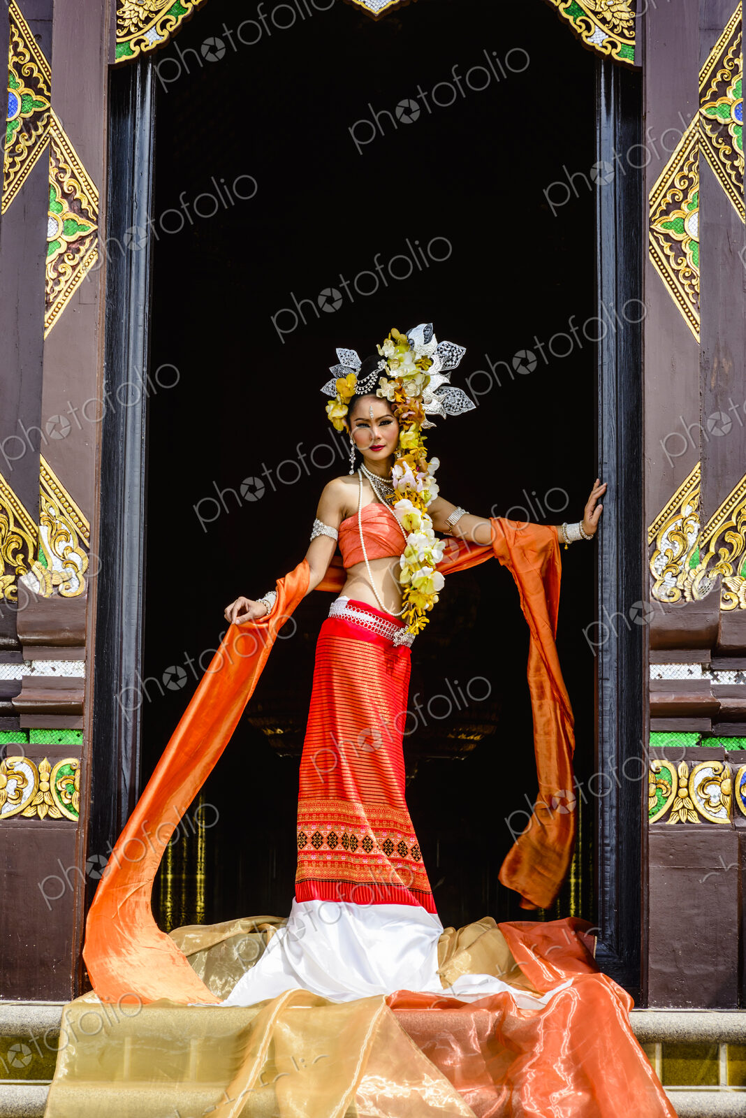 Asian woman standing in ornate temple doorway, Chiang Mai, Chiang Mai, Thailand