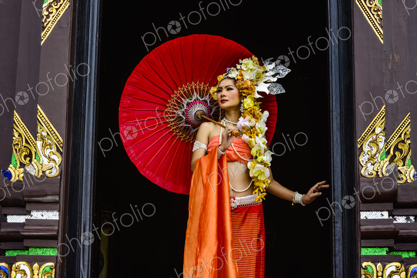 Asian woman standing in ornate temple doorway, Chiang Mai, Chiang Mai, Thailand