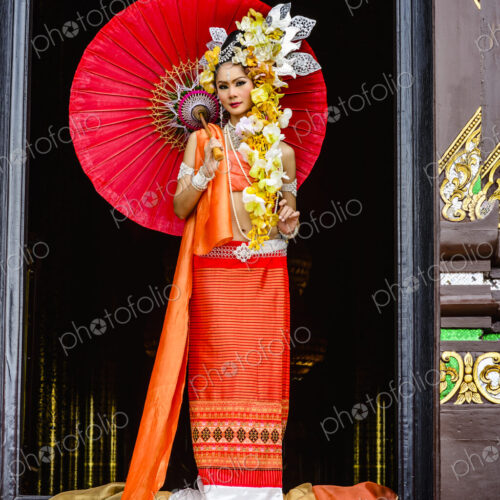 Asian woman standing in ornate temple doorway, Chiang Mai, Chiang Mai, Thailand Asian woman standing in ornate temple doorway, Chiang Mai, Chiang Mai, Thailand