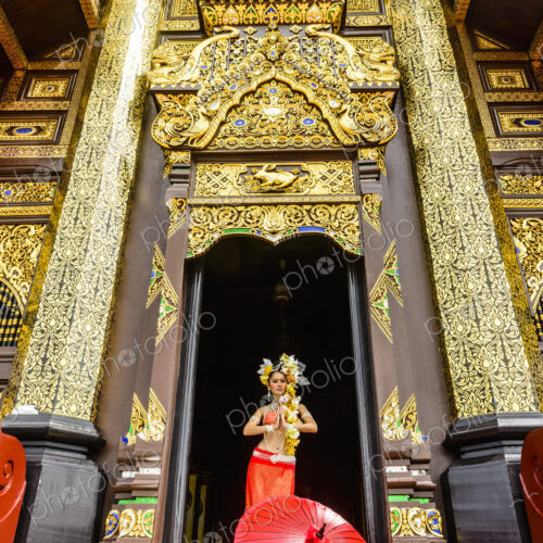 Asian woman standing in ornate temple doorway, Chiang Mai, Chiang Mai, Thailand Asian woman standing in ornate temple doorway, Chiang Mai, Chiang Mai, Thailand