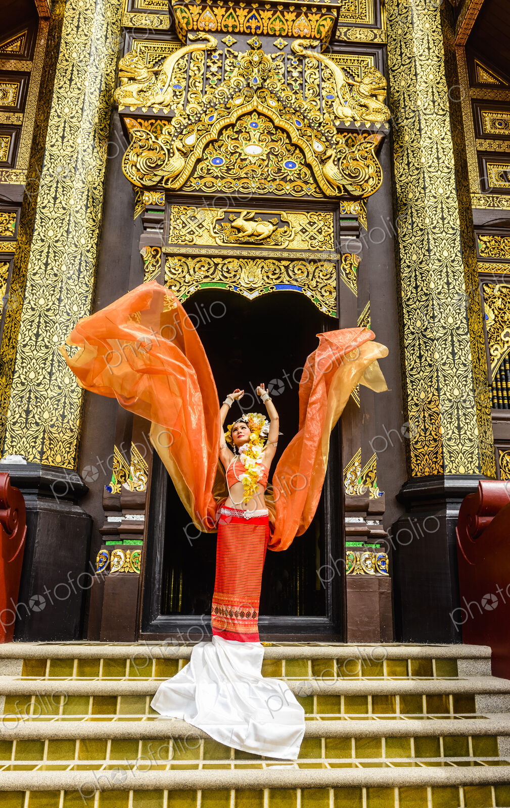 Asian woman standing on ornate temple stairs, Chiang Mai, Chiang Mai, Thailand