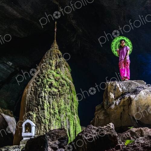 Asian woman standing on rock formation in cave temple Asian woman standing on rock formation in cave temple