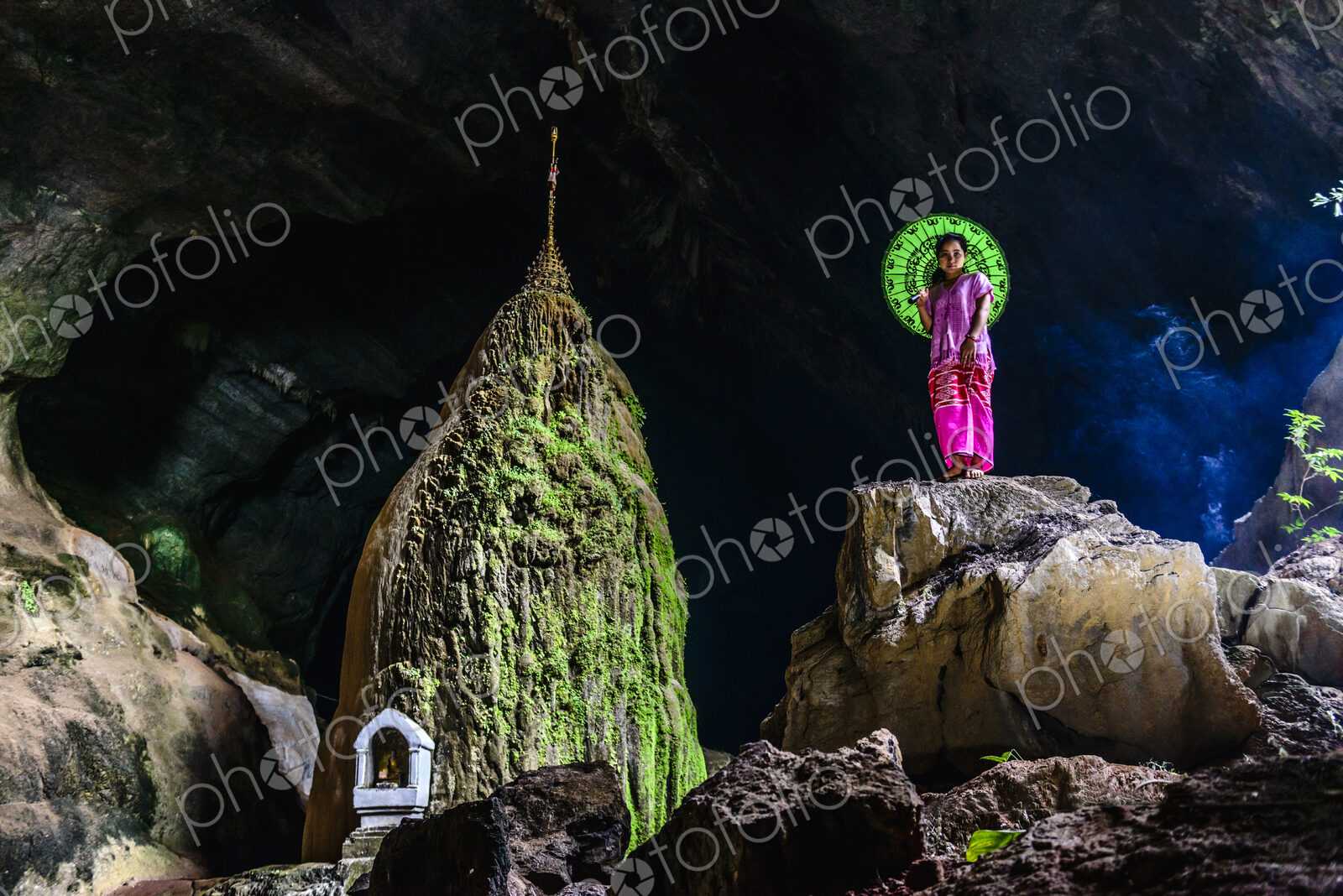 Asian woman standing on rock formation in cave temple
