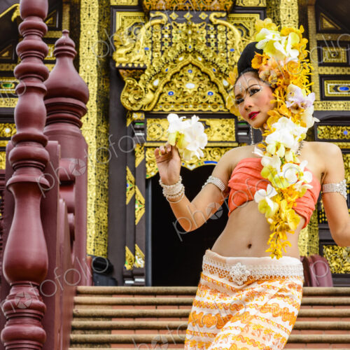 Asian woman standing on stairs of ornate Buddhist temple, Chiang Mai, Chiang Mai, Thailand Asian woman standing on stairs of ornate Buddhist temple, Chiang Mai, Chiang Mai, Thailand