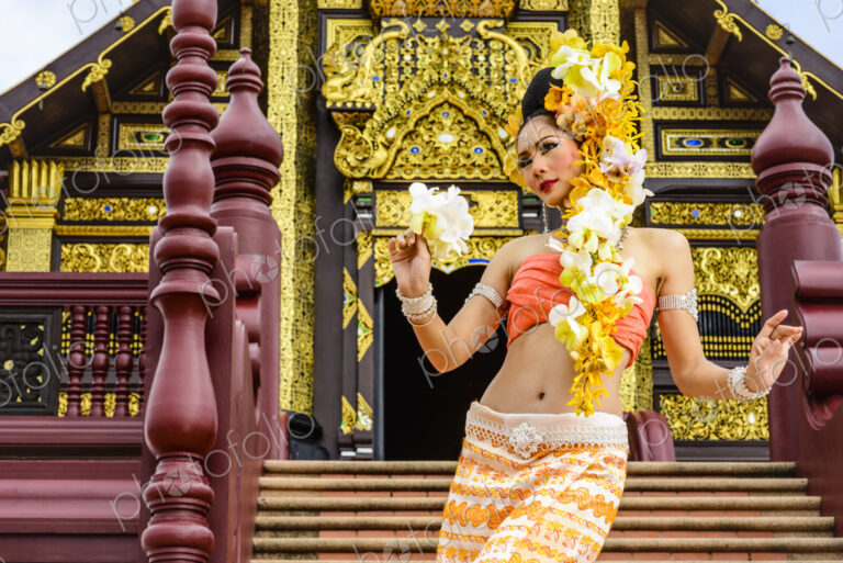 Asian woman standing on stairs of ornate Buddhist temple, Chiang Mai, Chiang Mai, Thailand