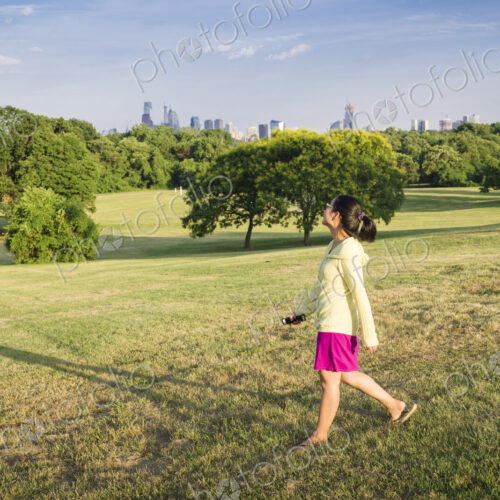 Asian woman walking in urban park