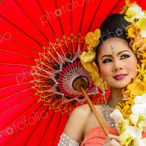 Asian woman with flower headdress holding parasol Asian woman with flower headdress holding parasol