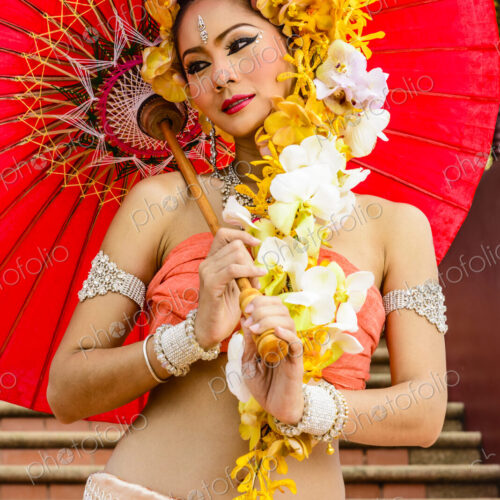 Asian woman with flower headdress holding parasol Asian woman with flower headdress holding parasol