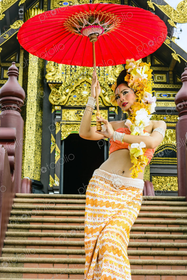 Asian woman with parasol on stairs of ornate Buddhist temple, Chiang Mai, Chiang Mai,…