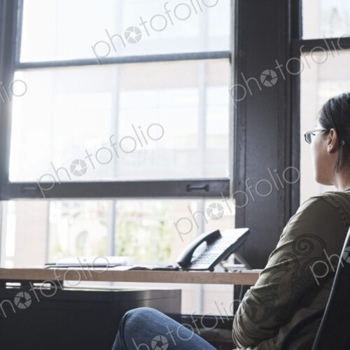 Asian woman working at her desk in a creative office.
