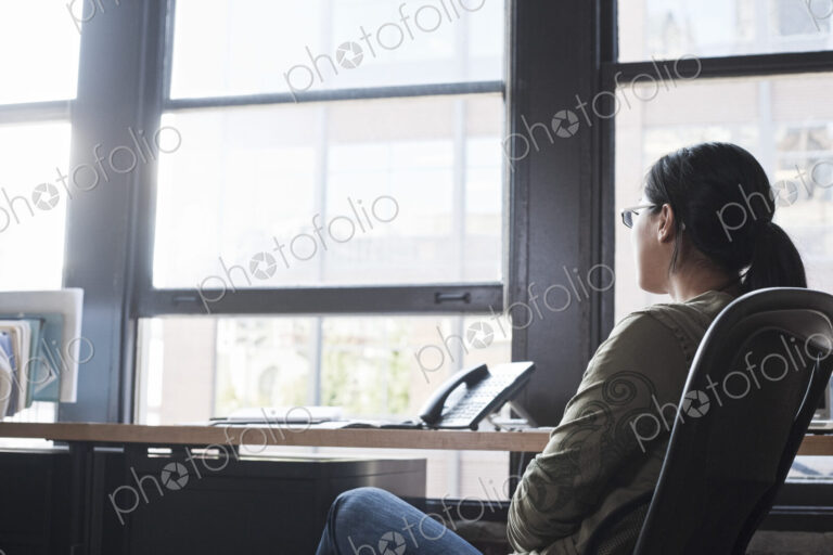 Asian woman working at her desk in a creative office.