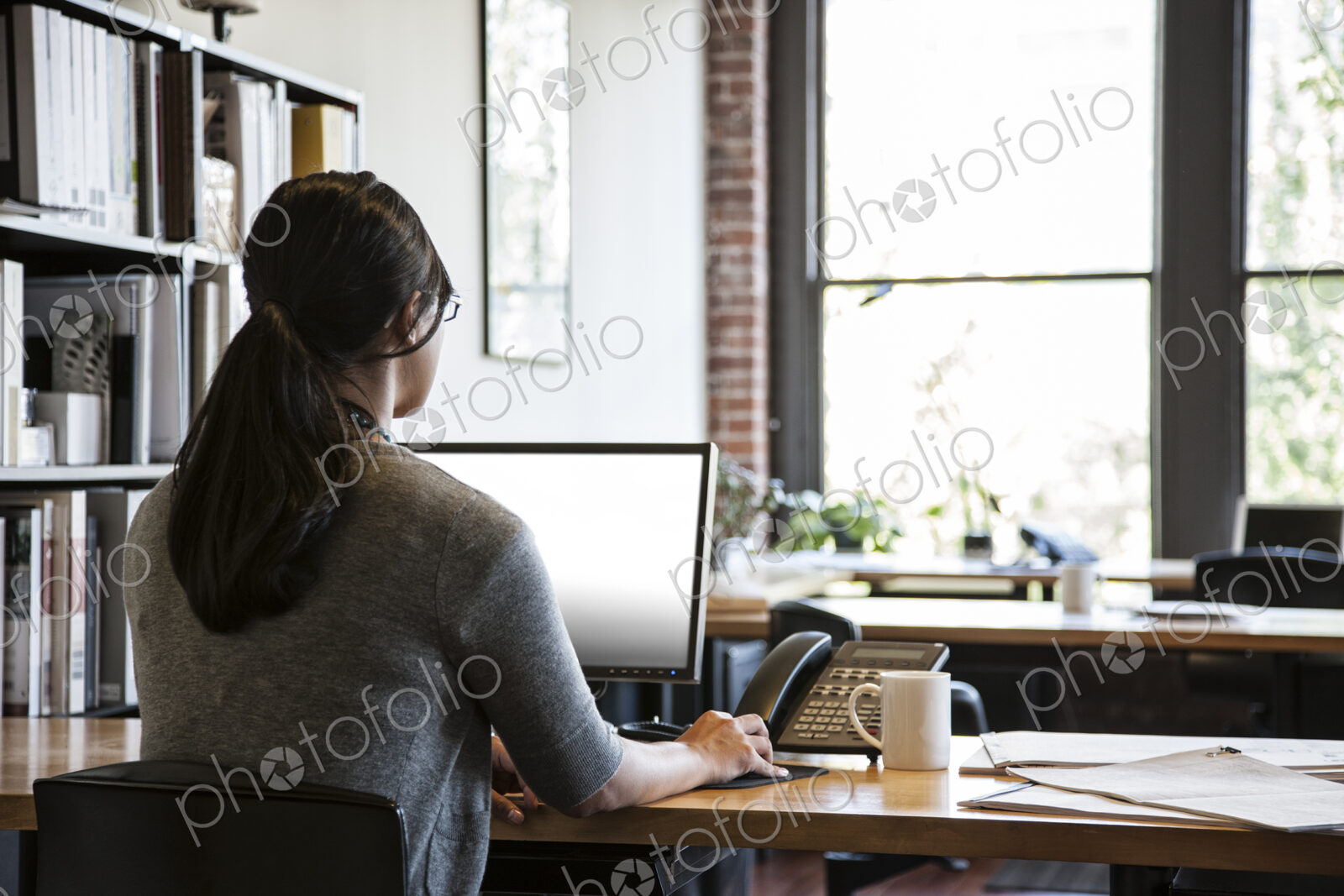 Asian woman working at her desk in a creative office.