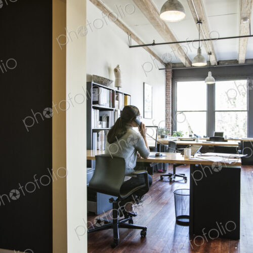 Asian woman working at her desk in a creative office.