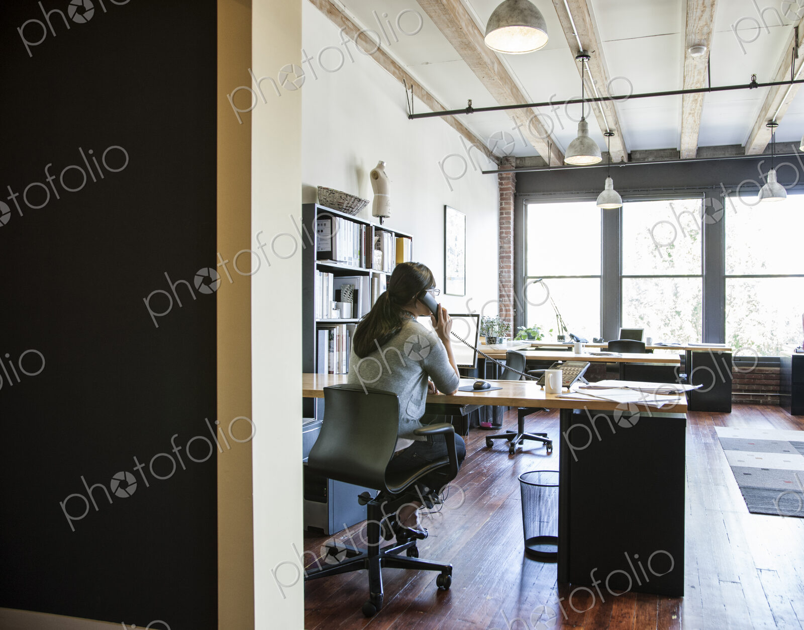 Asian woman working at her desk in a creative office.
