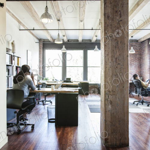 Asian woman working at her desk in a creative office. Asian woman working at her desk in a creative office.