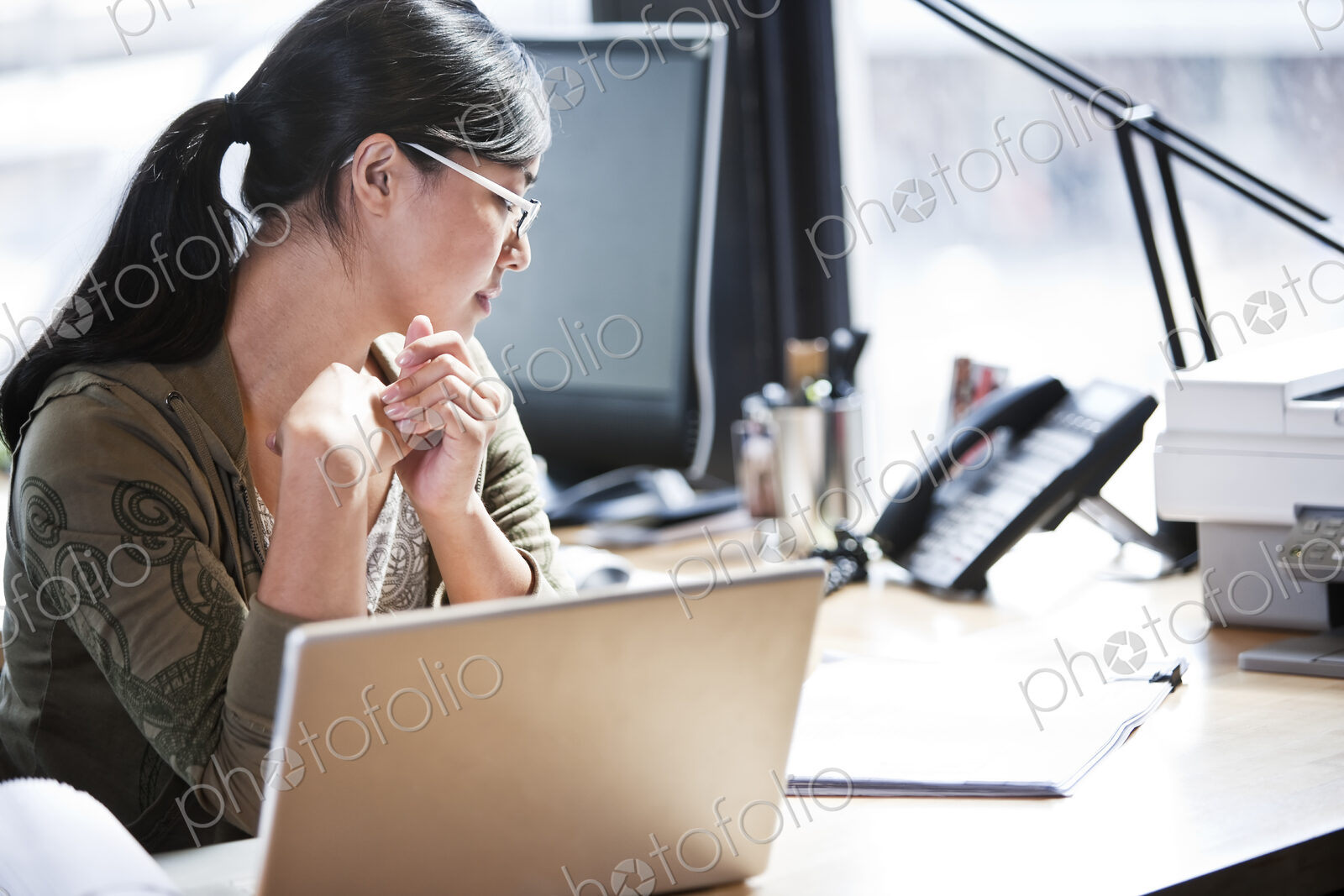 Asian woman working at her desk in a creative office.