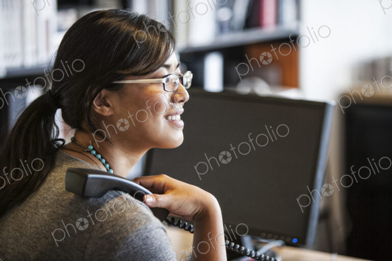 Asian woman working at her desk in a creative office.