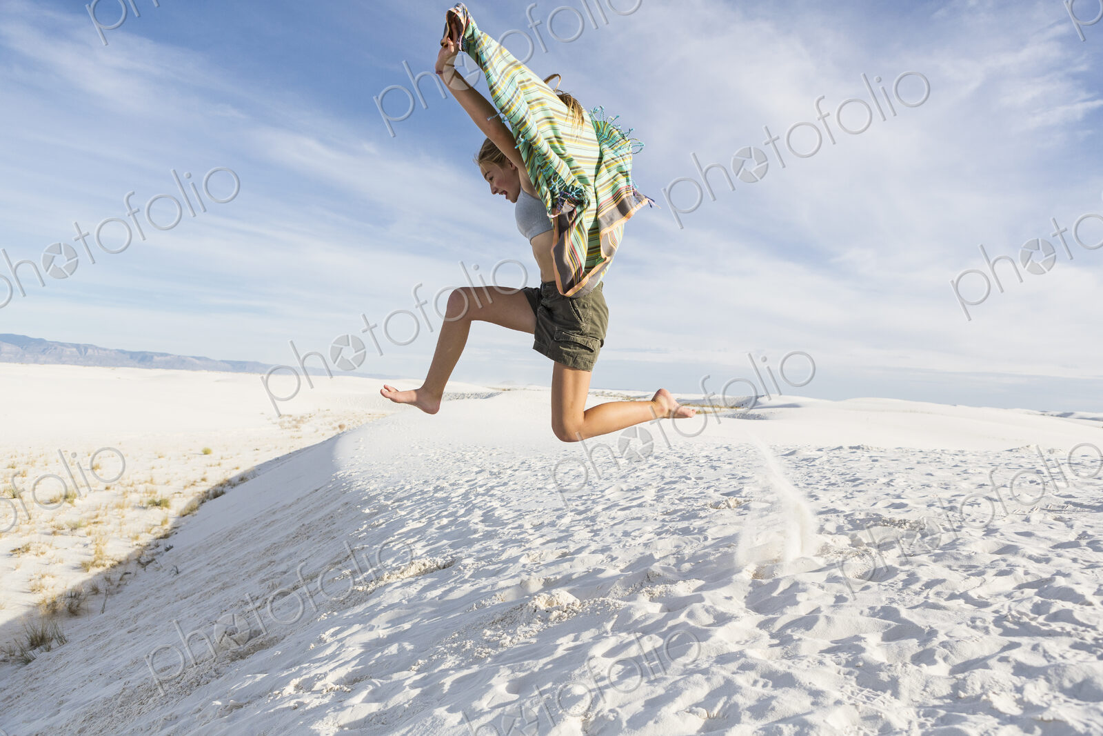 Athletic 13 year old girl leaping in the sand, White Sands Nat’l Monument, NM