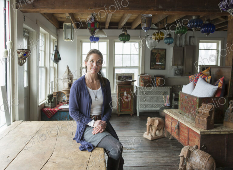 Awoman in an antique store in a small town, with objects and furniture from the past.