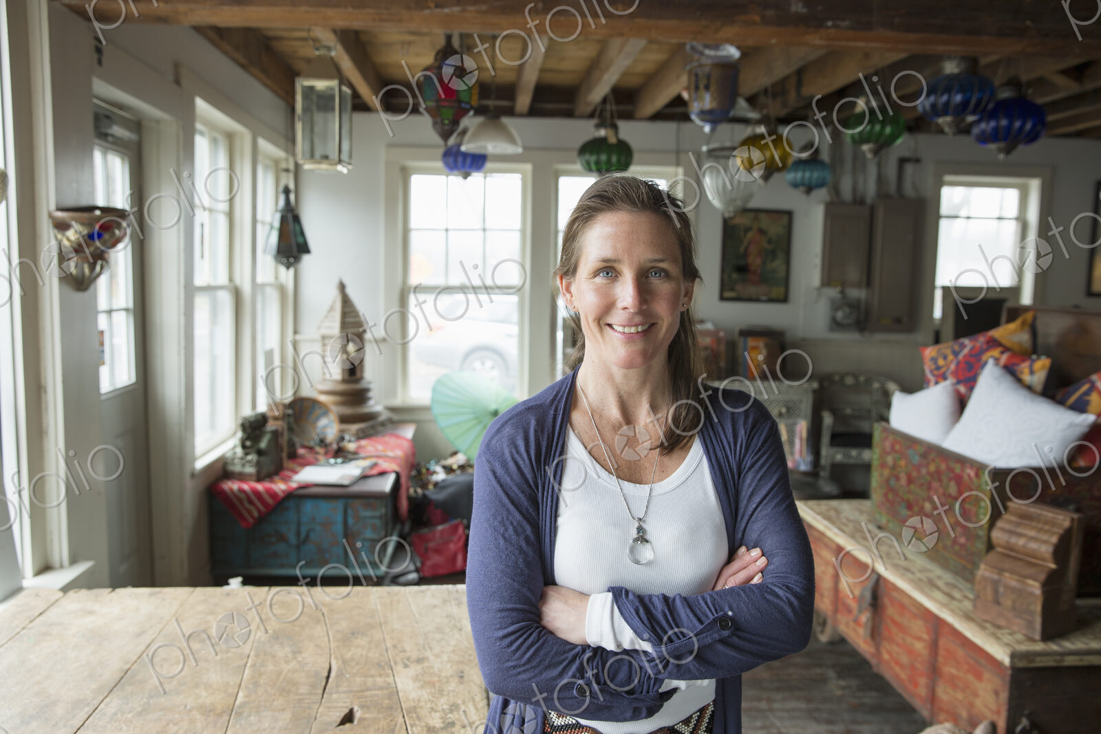Awoman in an antique store in a small town, with objects and furniture from the past.