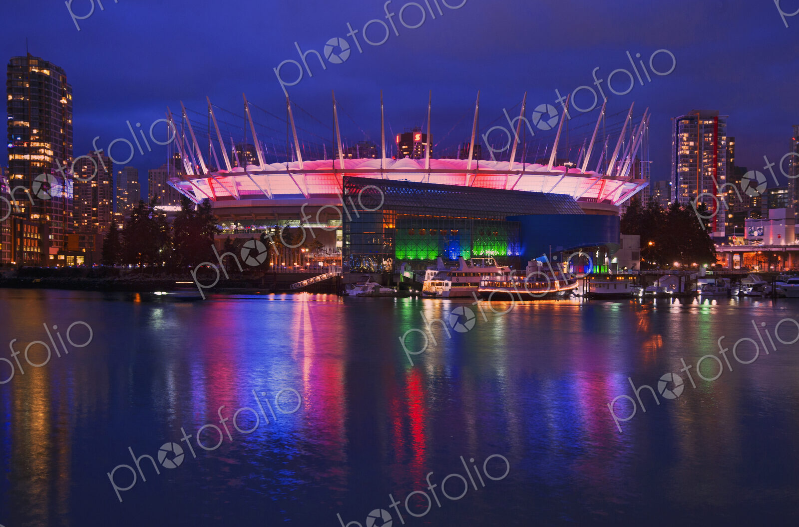 BC Place Stadium lit up at night on the Vancouver waterfront.
