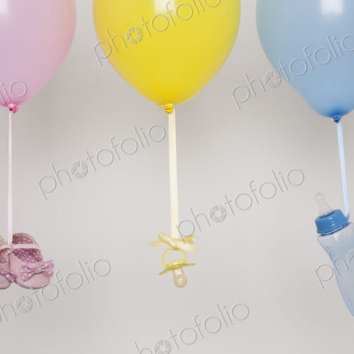 Baby bottles, pacifier and baby shoes tied by ribbon to balloons. Baby bottles, pacifier and baby shoes tied by ribbon to balloons.