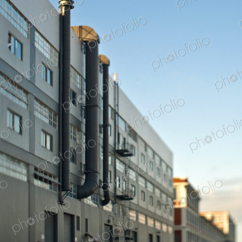 Back of a Factory Building in San Francisco, with exterior pipes, and and large doors…