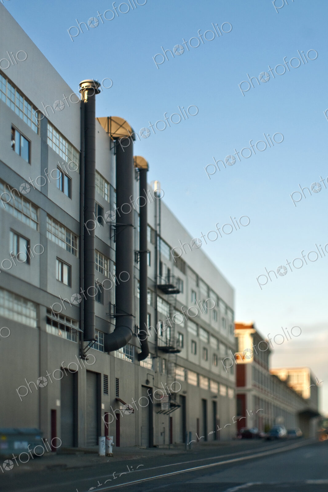 Back of a Factory Building in San Francisco, with exterior pipes, and and large doors…