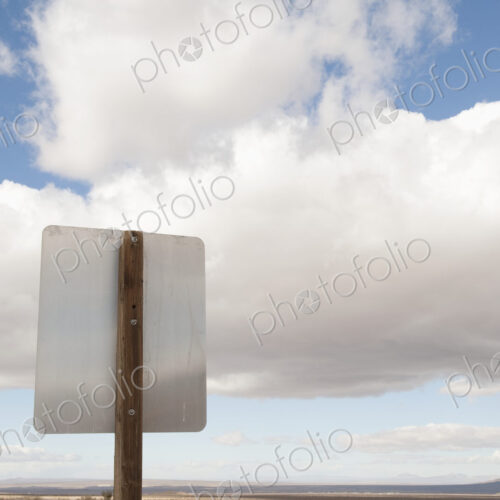Back of road sign against blue sky and clouds Back of road sign against blue sky and clouds