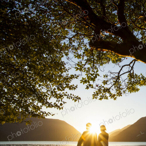 Backlit couple standing by lake Crescent at sunset, Olympic National Park. Backlit couple standing by lake Crescent at sunset, Olympic National Park.