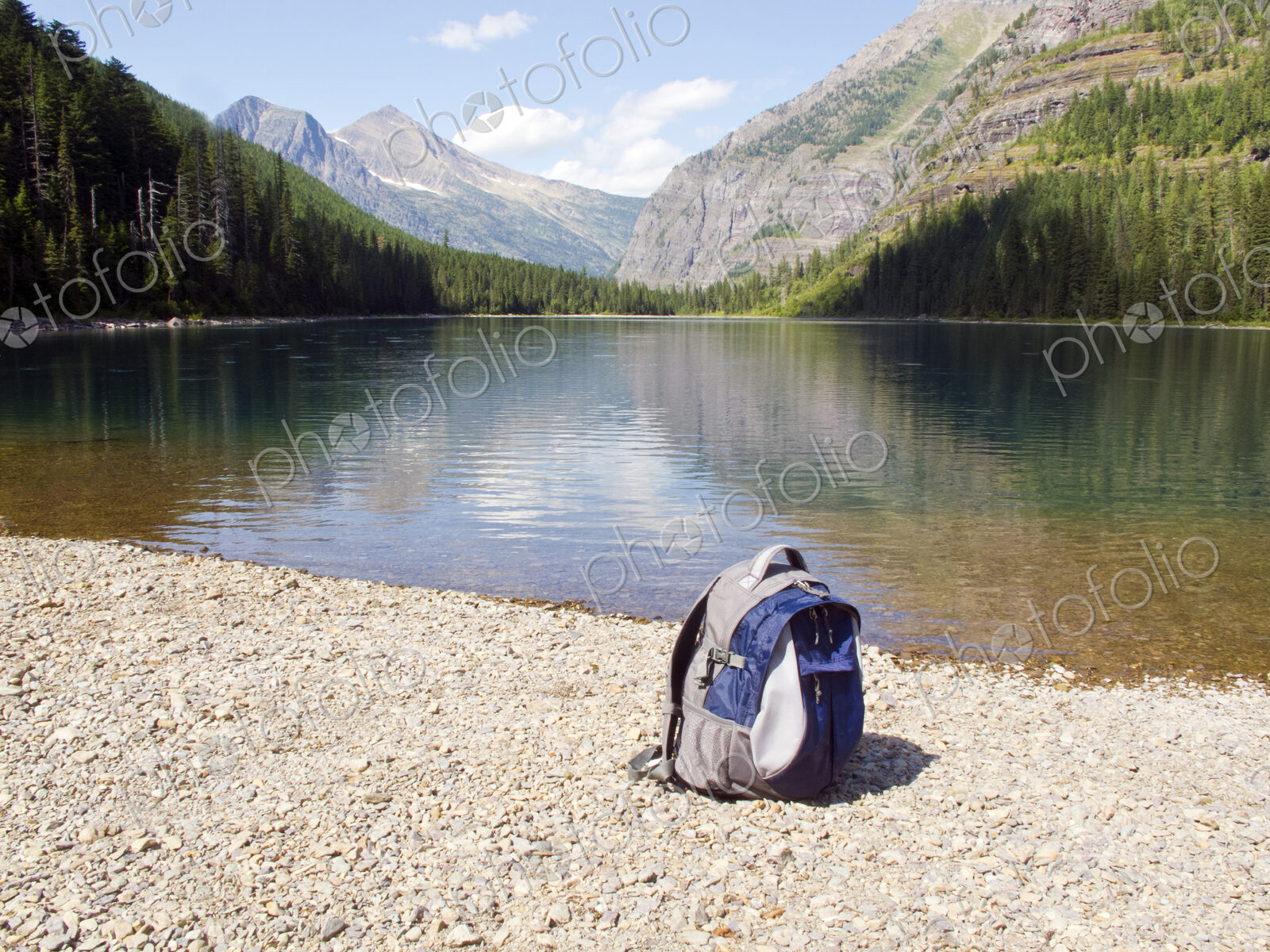 Backpack at mountain lake, Glacier National Park, Montana, United States