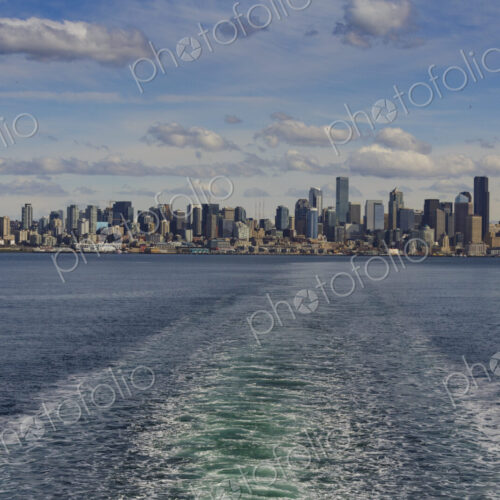 Baingbridge Ferry wake and skyline view of Seattle and the Cascade mountains in the… Baingbridge Ferry wake and skyline view of Seattle and the Cascade mountains in the…
