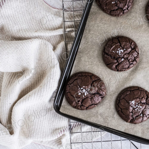 Baked chocolate brownies on a baking tray placed on a wire cooling rack. Baked chocolate brownies on a baking tray placed on a wire cooling rack.