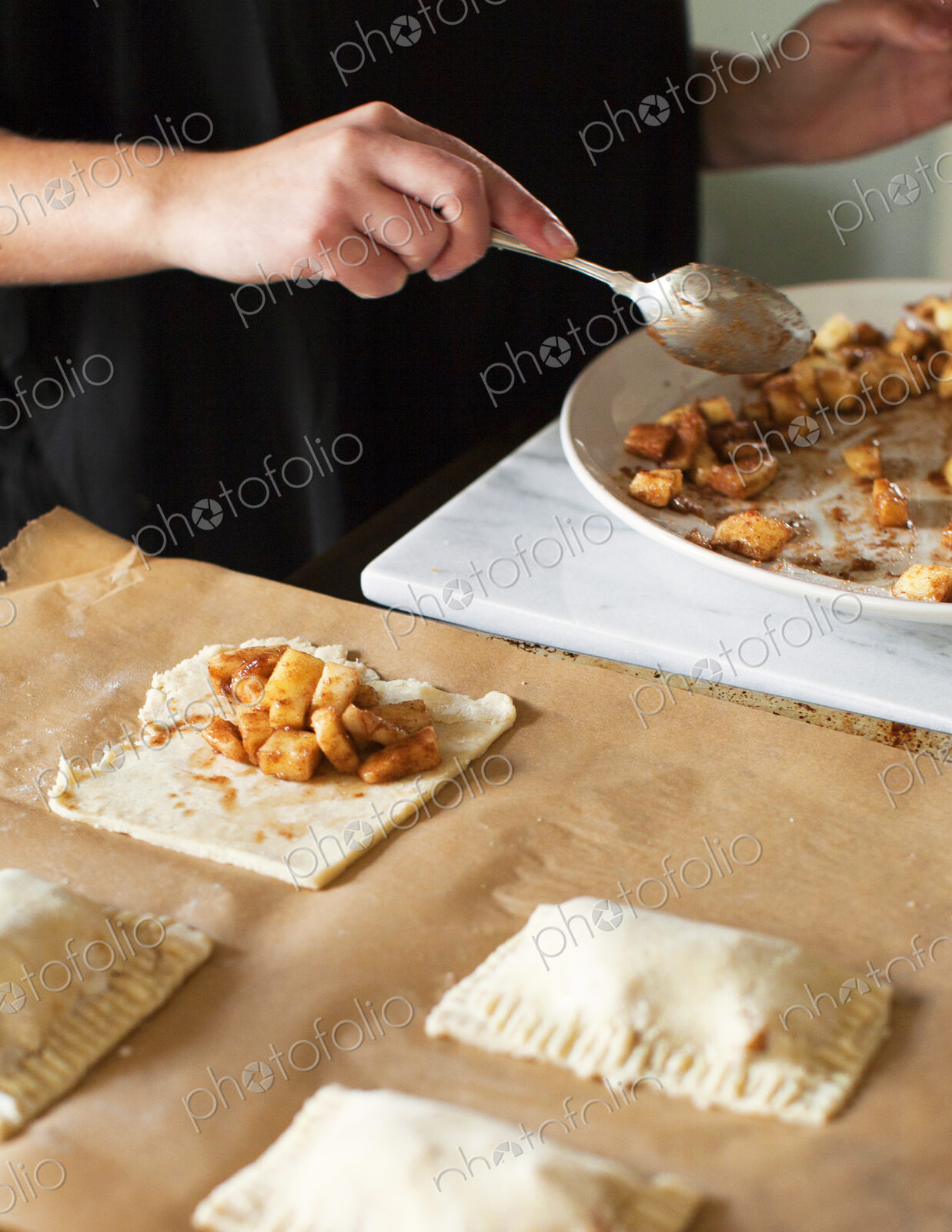 Baker filling miniature apple pies