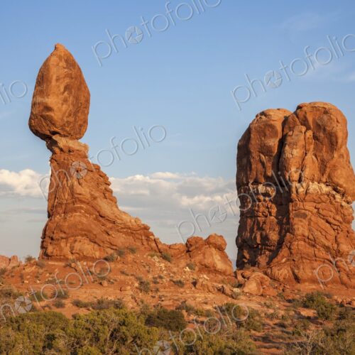 Balanced Rock glows in the warm light of sunset in Arches National Park, Utah,…