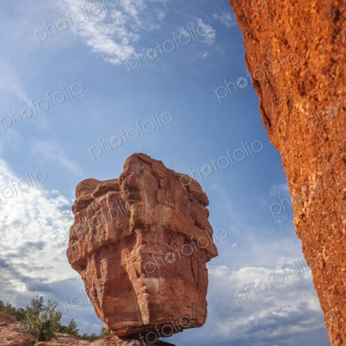 Balanced Rock rises from red sandstone in Garden of the Gods, Colorado Springs, framed… Balanced Rock rises from red sandstone in Garden of the Gods, Colorado Springs, framed…
