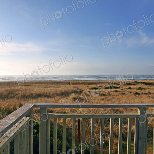 Balcony overlooking grassy field and beach Balcony overlooking grassy field and beach