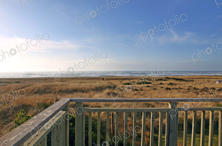 Balcony overlooking grassy field and beach