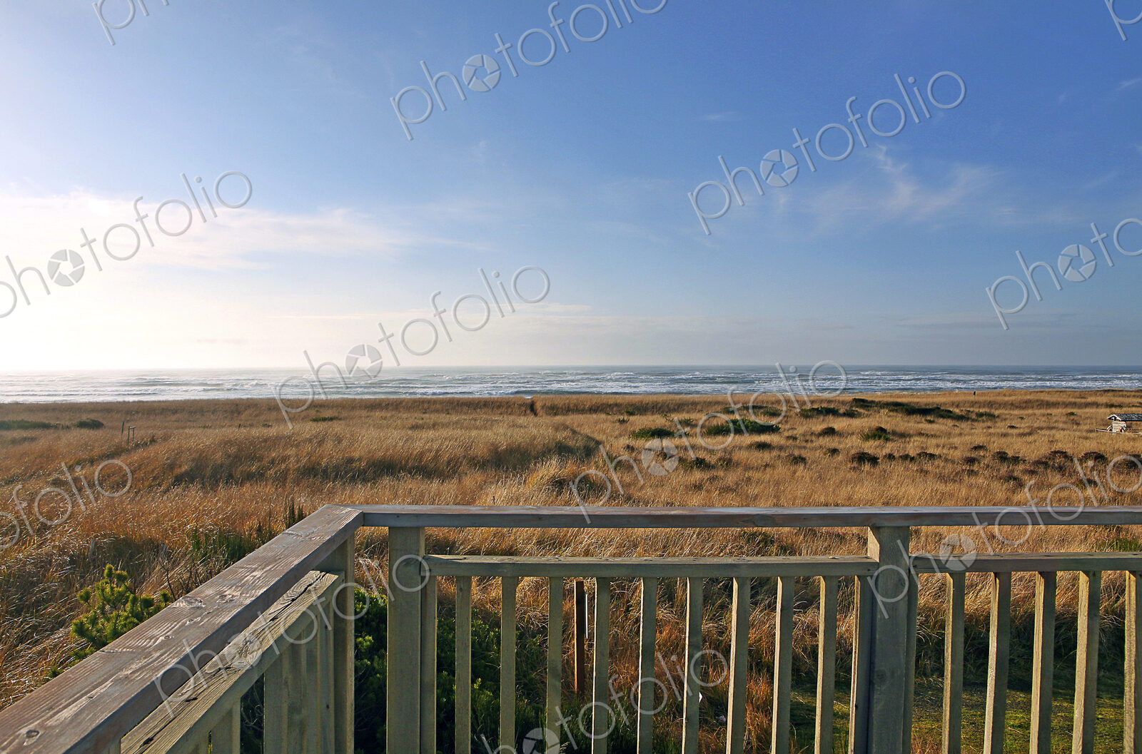 Balcony overlooking grassy field and beach