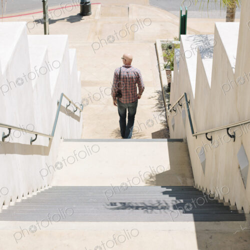 Bald man walking down a staircase. Bald man walking down a staircase.