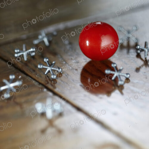 Ball and jacks counters on a wooden surface. Ball and jacks counters on a wooden surface.