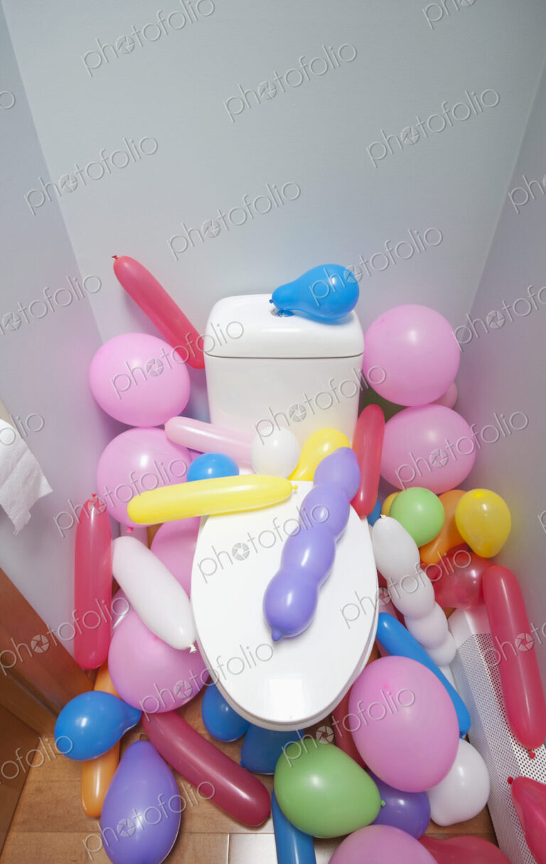 Balloons in a Bathroom surrounding a toilet
